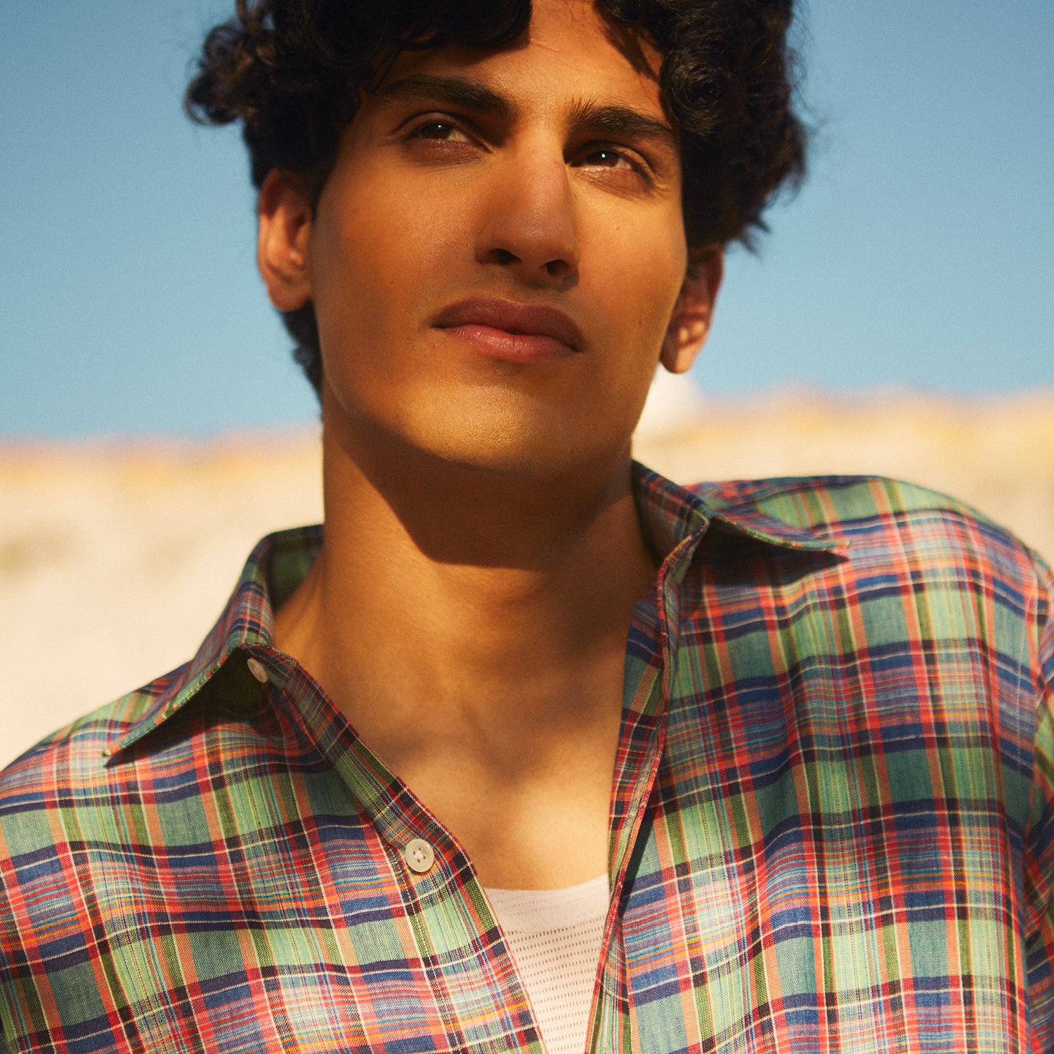 View 3 of product The Turnbull & Asser Green and Red Madras Check Weekend Fit Linen Shirt features a Derby collar, 1-button cuff, and colorful plaid pattern, crafted from sustainable linen and shown against a plain white background.