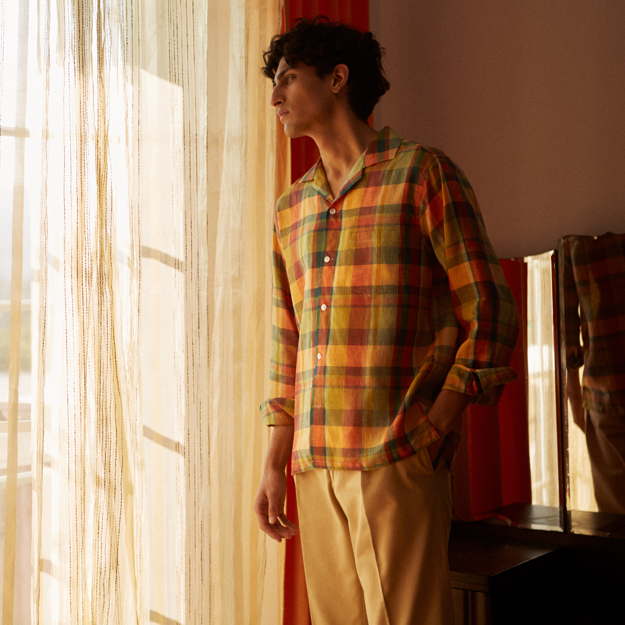 View 2 of product Turnbull & Asser's Orange Madras Check Holiday Fit Long Sleeve Linen Shirt features a bold plaid in orange, yellow, green, and blue with a revere collar and 1-button cuff—ideal for effortless holiday style. Laid flat on white background.