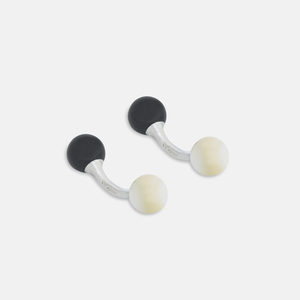 Turnbull & Asser's Reversible Onyx and Mother-of-Pearl Bulb Sterling Silver Cufflinks have curved bars with black onyx on one end and white mother-of-pearl on the other, perfect for elevating a black tie look. Shown on a plain white background.