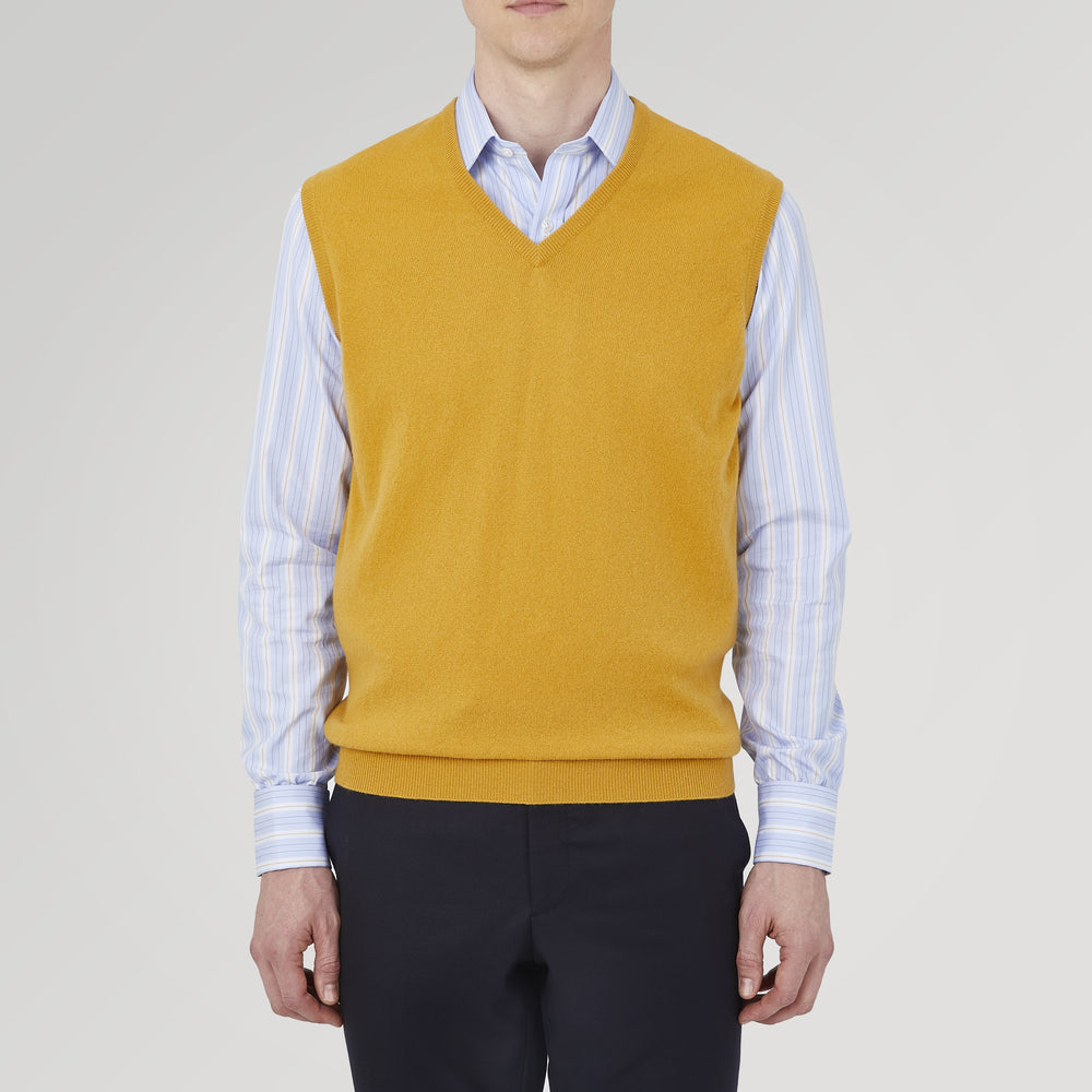 The Sunflower Yellow V-Neck Cashmere Slipover by Turnbull & Asser is neatly folded on a white background, showing the front and label—ideal for formal layering or as a versatile cashmere addition to your wardrobe.