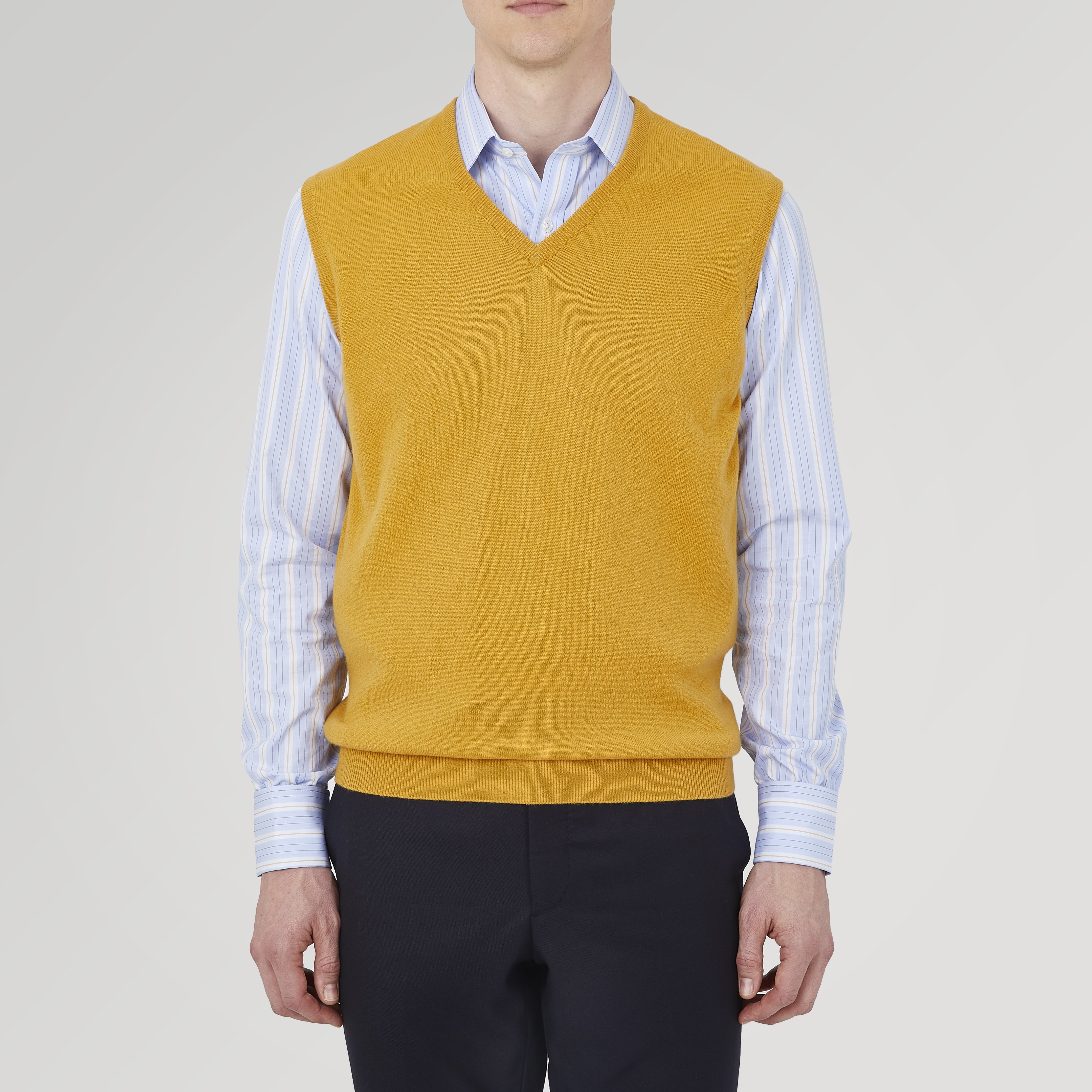 View 2 of product The Sunflower Yellow V-Neck Cashmere Slipover by Turnbull & Asser is neatly folded on a white background, showing the front and label—ideal for formal layering or as a versatile cashmere addition to your wardrobe.