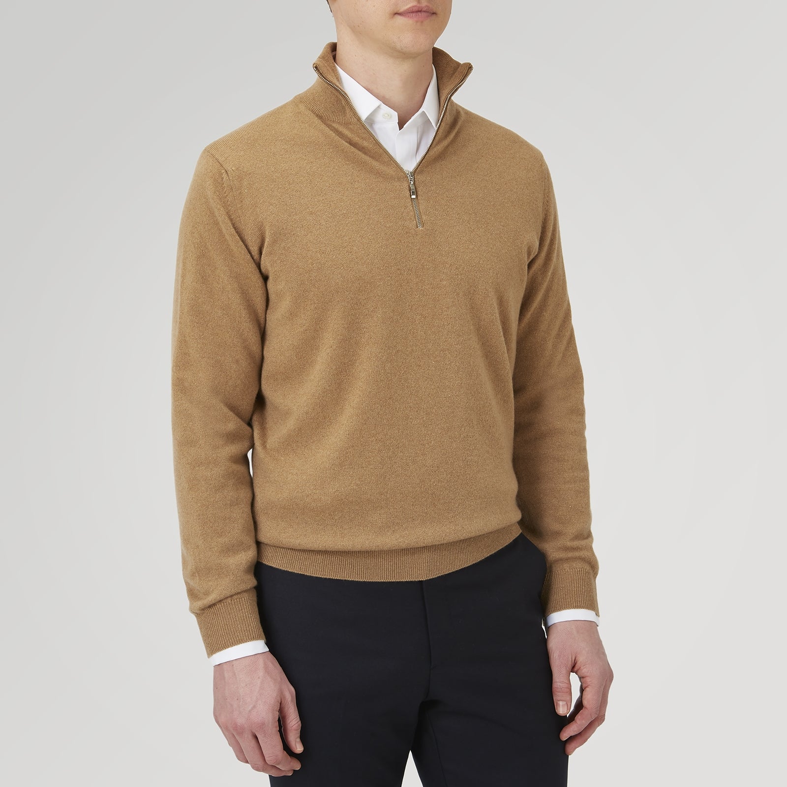 View 3 of product The Turnbull & Asser Natural Half-Zip Cashmere Jumper, light brown with a high collar and silver zip, is folded neatly against a white background. One sleeve shows its ribbed cuff—ideal for stylish layering.