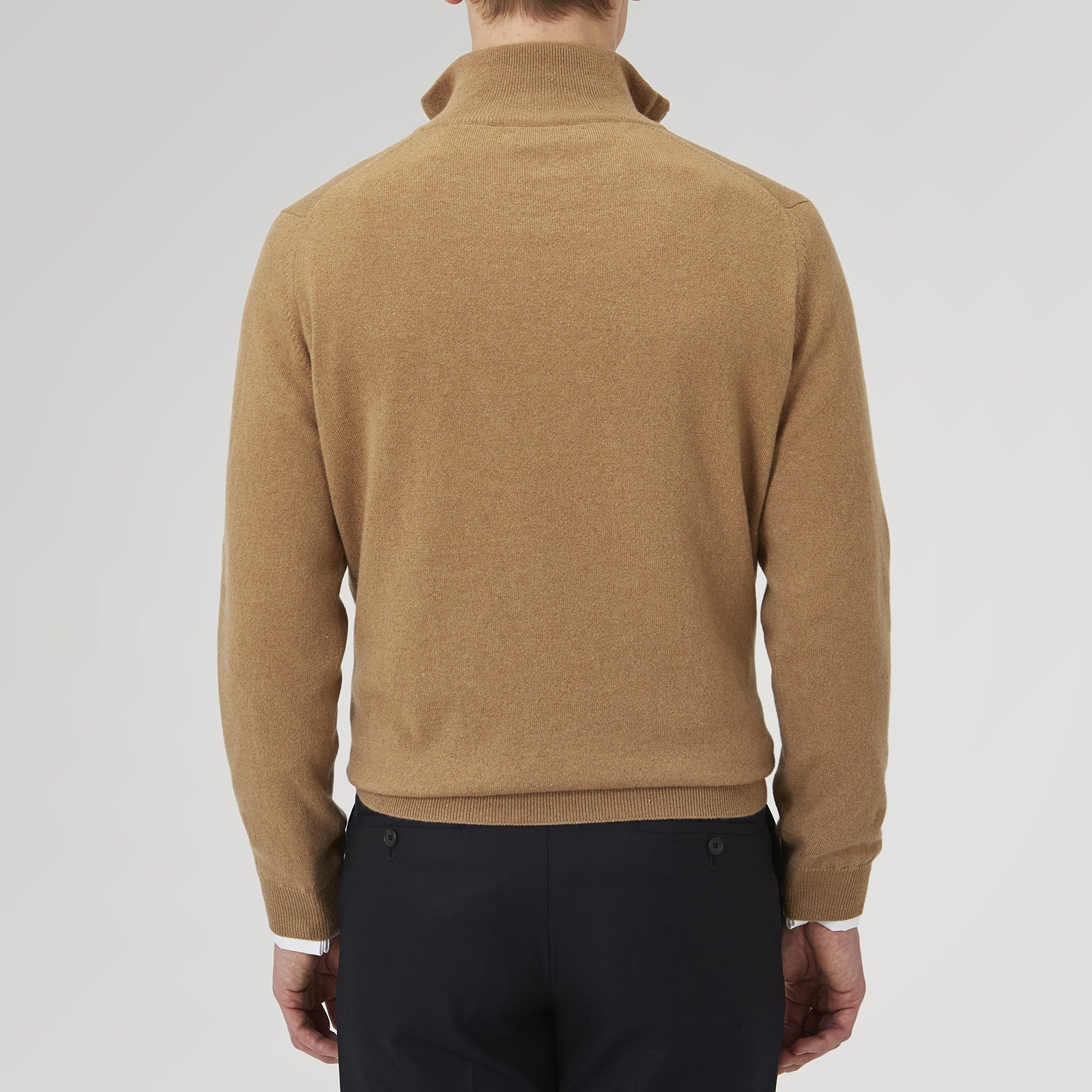 View 4 of product The Turnbull & Asser Natural Half-Zip Cashmere Jumper, light brown with a high collar and silver zip, is folded neatly against a white background. One sleeve shows its ribbed cuff—ideal for stylish layering.