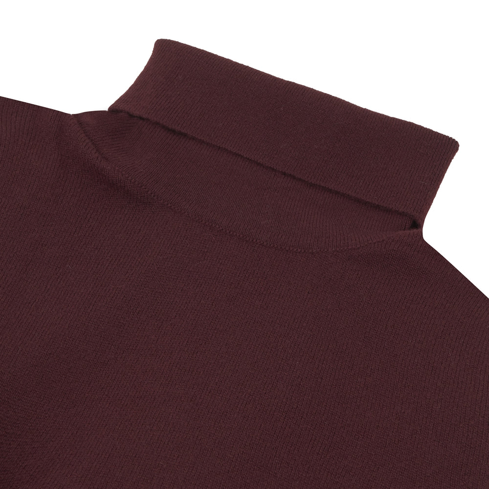 A folded, long-sleeve Port Cashmere Roll Neck Jumper by Turnbull & Asser in burgundy is displayed on a white background, highlighting this stylish men's autumn piece.