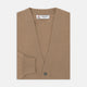 A Natural Cashmere Cardigan by Turnbull & Asser, light brown with a V-neckline, ribbed cuffs, and button closure, is neatly folded and displayed against a white background.