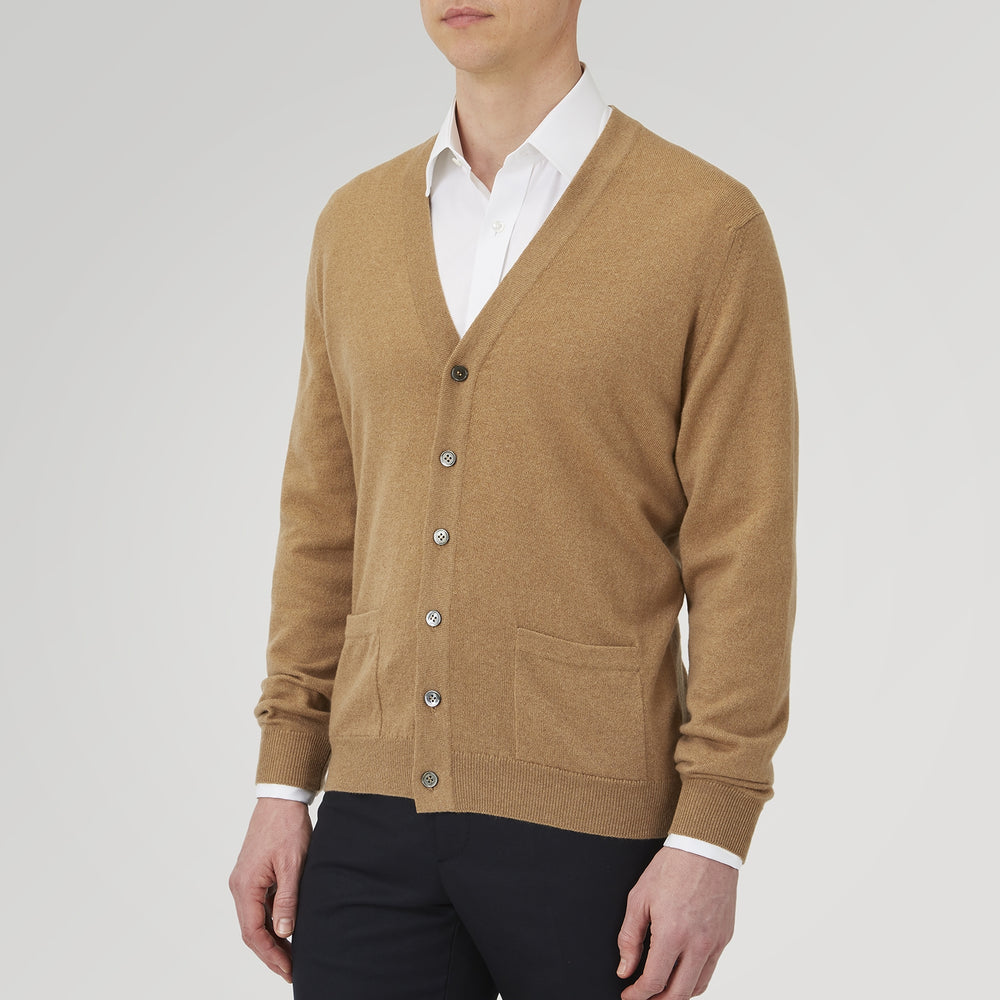 A Natural Cashmere Cardigan by Turnbull & Asser, light brown with a V-neckline, ribbed cuffs, and button closure, is neatly folded and displayed against a white background.