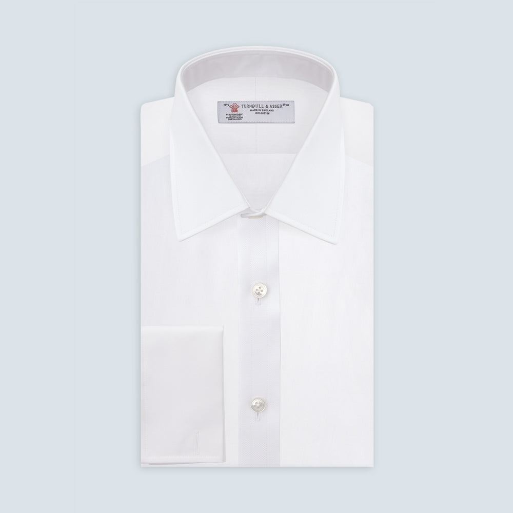 The Turnbull & Asser White Superfine Oxford Cotton Shirt features a T&A collar, double cuffs, and a left chest pocket. Displayed on a light gray background, it includes a visible label inside the collar—ideal for smart evening wear.