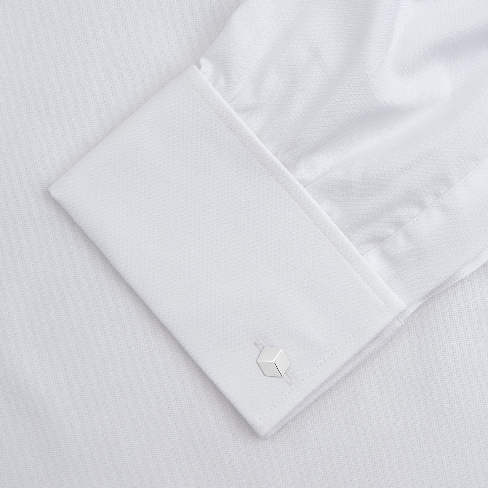 View 4 of product The Turnbull & Asser White Superfine Oxford Cotton Shirt features a T&A collar, double cuffs, and a left chest pocket. Displayed on a light gray background, it includes a visible label inside the collar—ideal for smart evening wear.