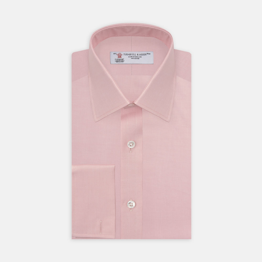 The Turnbull & Asser Pink Superfine Oxford Cotton Shirt features a T&A collar, double cuffs, and white buttons, neatly folded against a plain white background.
