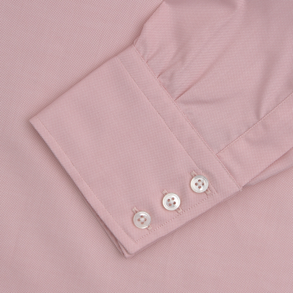 The Turnbull & Asser Pink Superfine Oxford Cotton Shirt features a T&A collar, double cuffs, and white buttons, neatly folded against a plain white background.