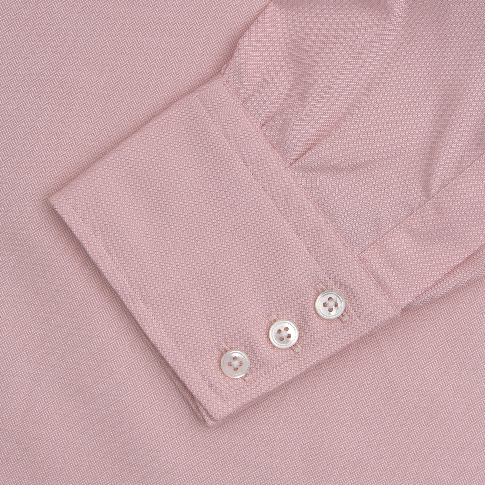 View 4 of product The Turnbull & Asser Pink Superfine Oxford Cotton Shirt features a T&A collar, double cuffs, and white buttons, neatly folded against a plain white background.
