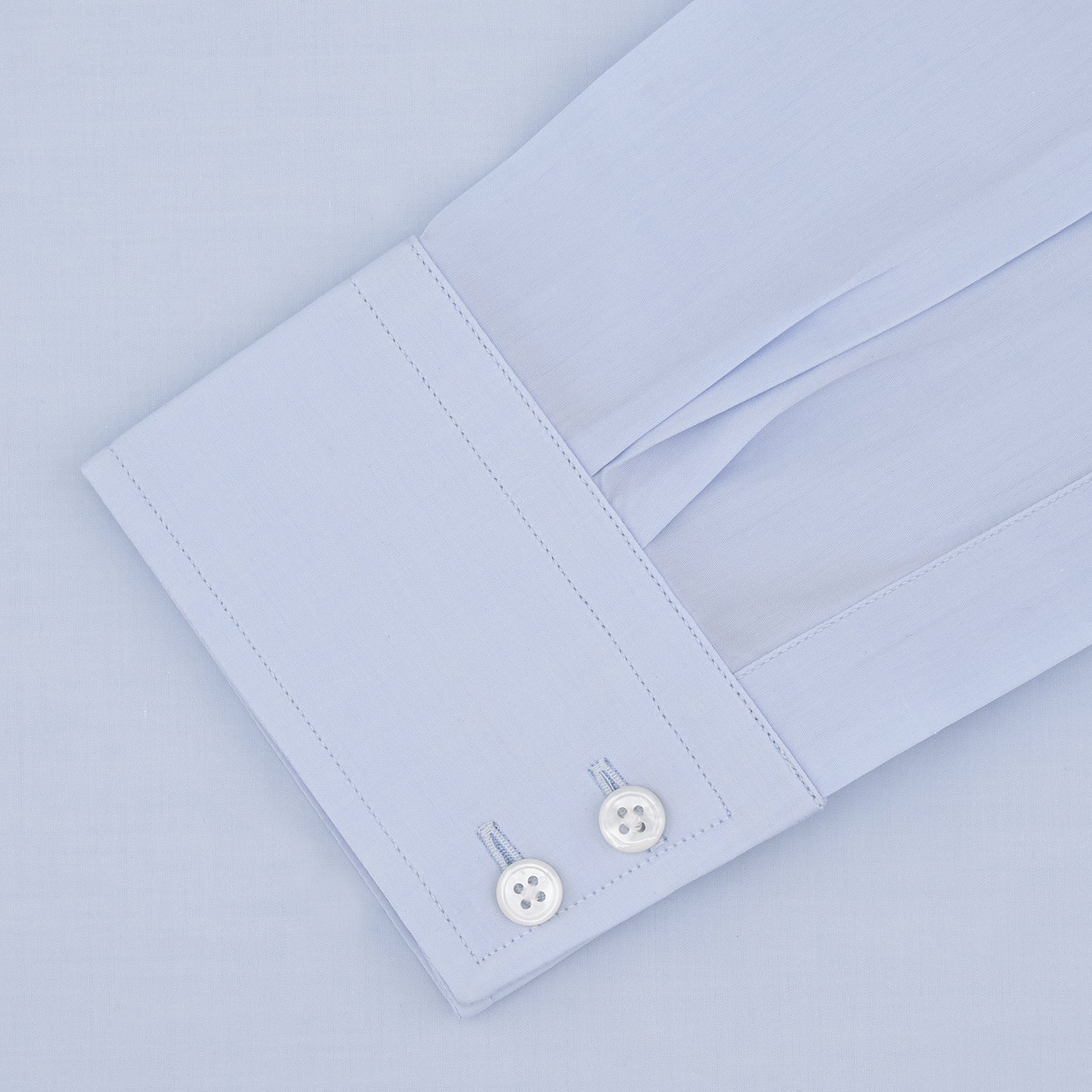 View 4 of product Turnbull & Asser's Tailored Fit Two-Fold 120 Light Blue Shirt features a classic Kent collar, white buttons, long sleeves with 2-button cuffs, and an inner collar label.