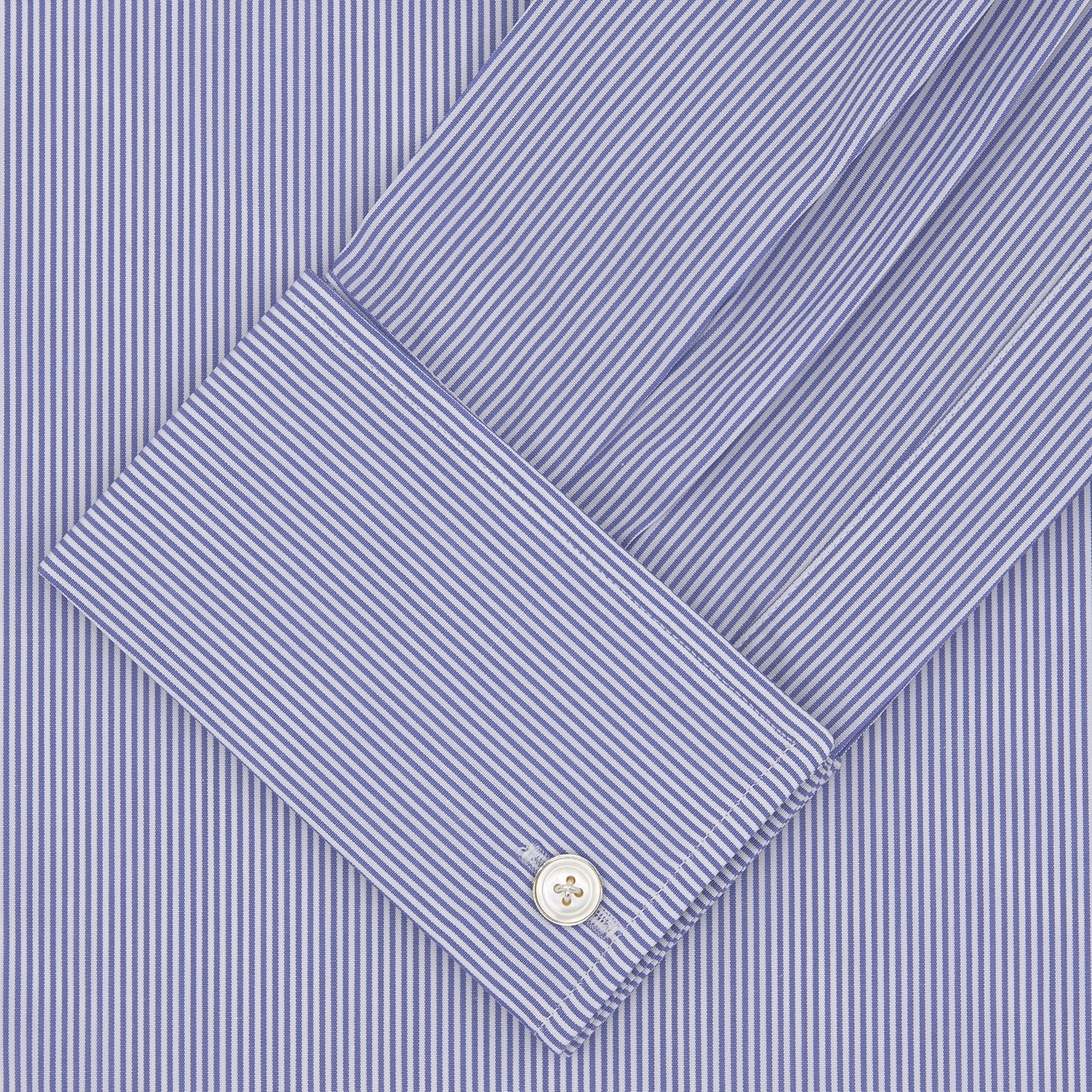 View 4 of product The Turnbull & Asser Tailored Fit Blue Fine Bengal Stripe Cotton Shirt features a Kent collar, double cuffs, and thin white stripes. Displayed neatly folded against a white background.
