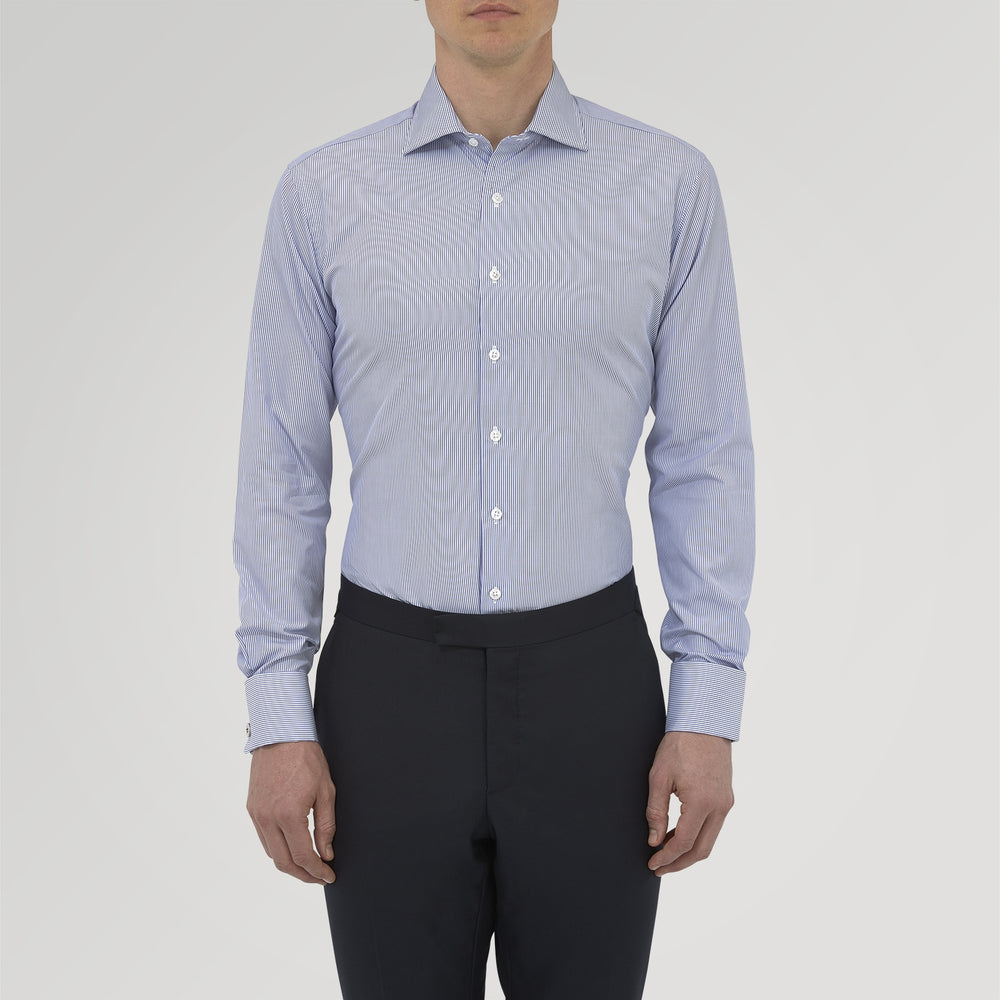 The Turnbull & Asser Tailored Fit Blue Fine Bengal Stripe Cotton Shirt features a Kent collar, double cuffs, and thin white stripes. Displayed neatly folded against a white background.