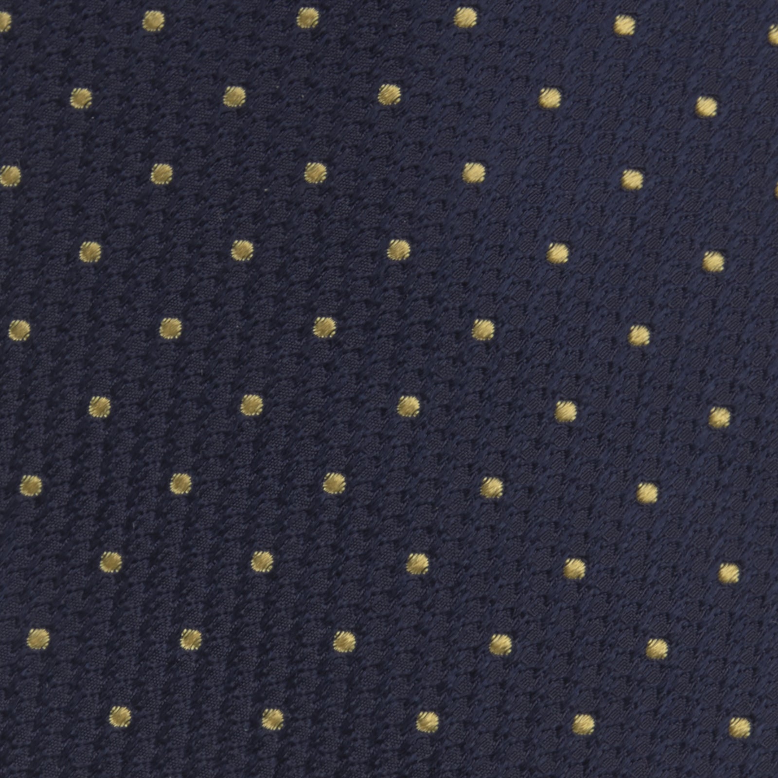 View 3 of product The Turnbull & Asser Navy and Gold Spot Lace Silk Tie, ideal for office wear, is shown rolled up on a white background.