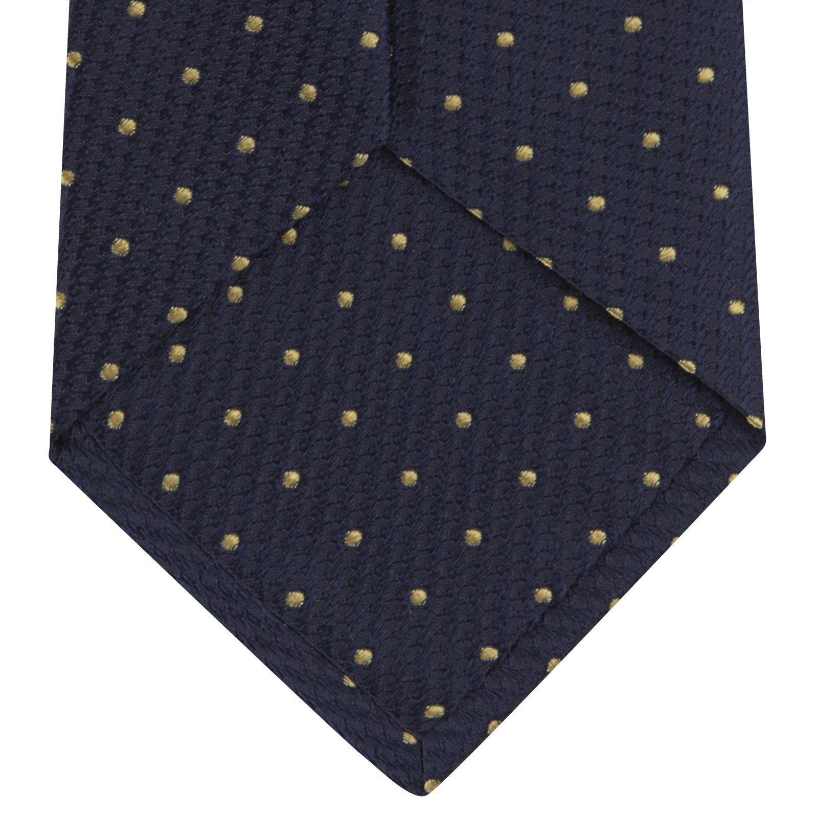 View 4 of product The Turnbull & Asser Navy and Gold Spot Lace Silk Tie, ideal for office wear, is shown rolled up on a white background.