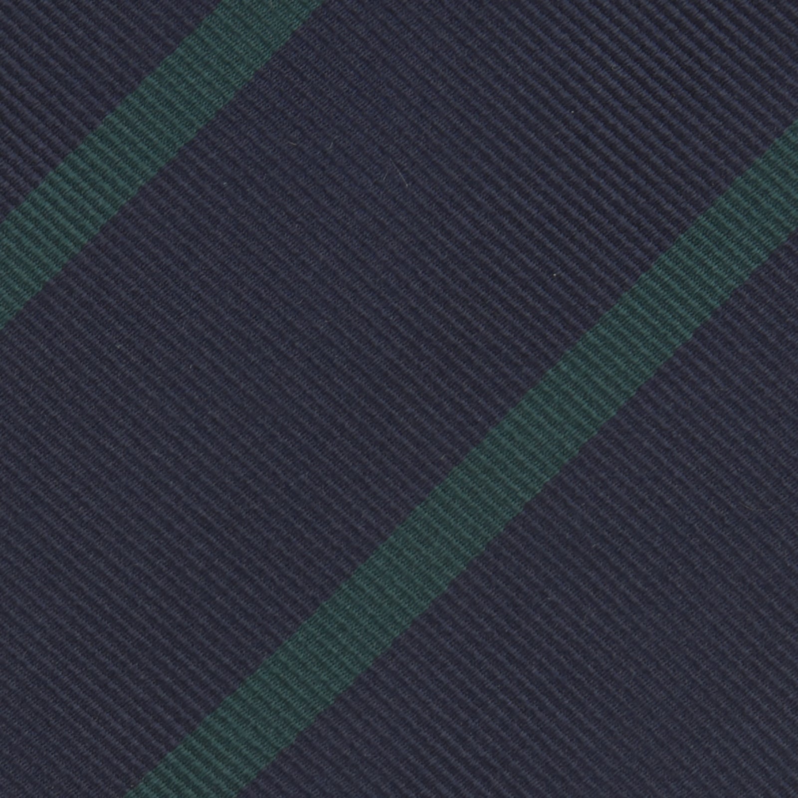 View 3 of product The Turnbull & Asser Navy and Green Blazer Stripe Repp Silk Tie features diagonal green stripes on navy silk, shown rolled at one end against a white background.