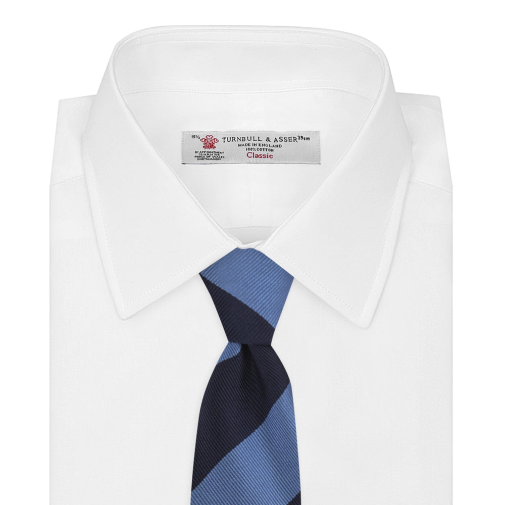 The Turnbull & Asser Navy and Blue Block Stripe Repp Silk Tie features wide navy and blue diagonal stripes on luxurious textured silk, elegantly presented against a white background.