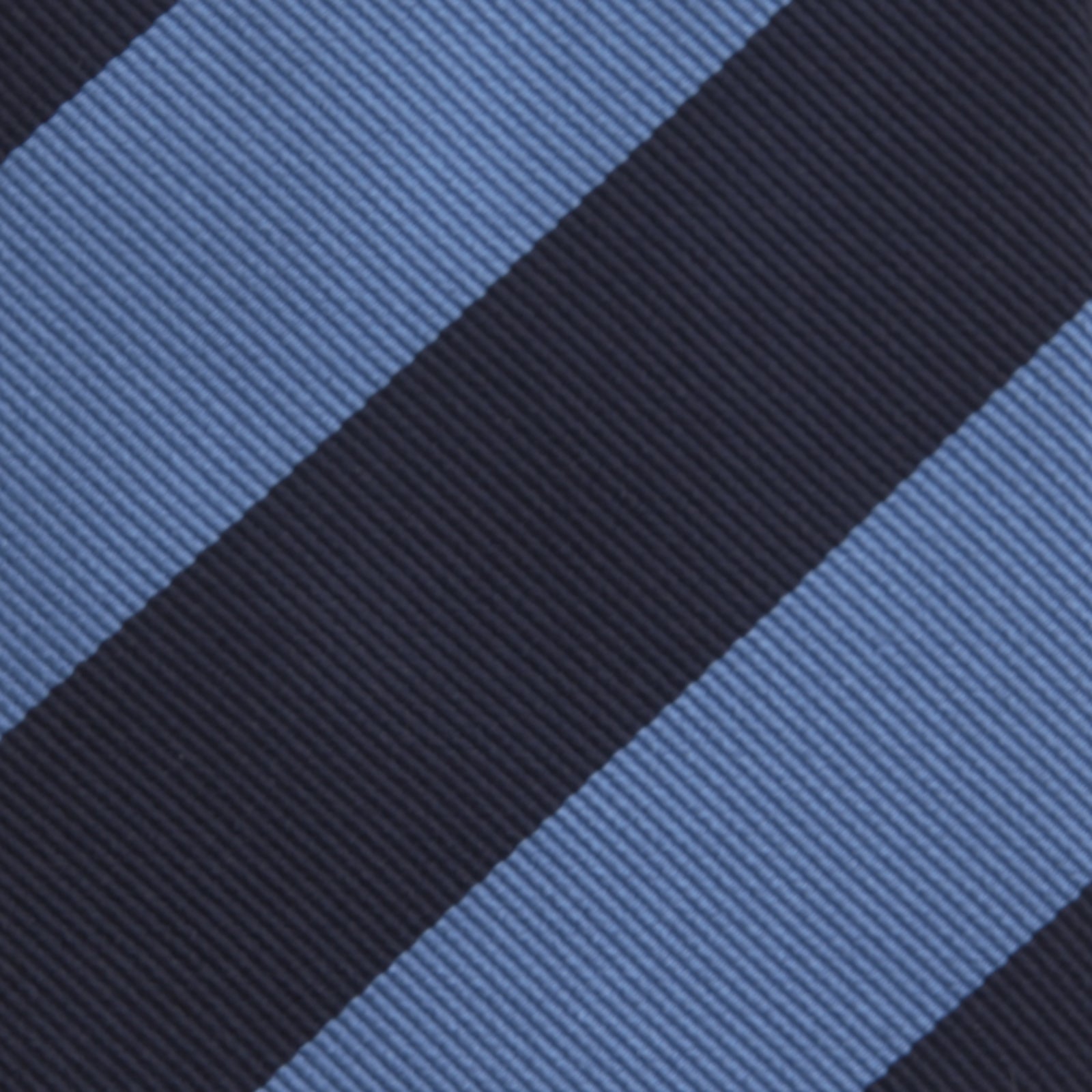 View 3 of product The Turnbull & Asser Navy and Blue Block Stripe Repp Silk Tie features wide navy and blue diagonal stripes on luxurious textured silk, elegantly presented against a white background.