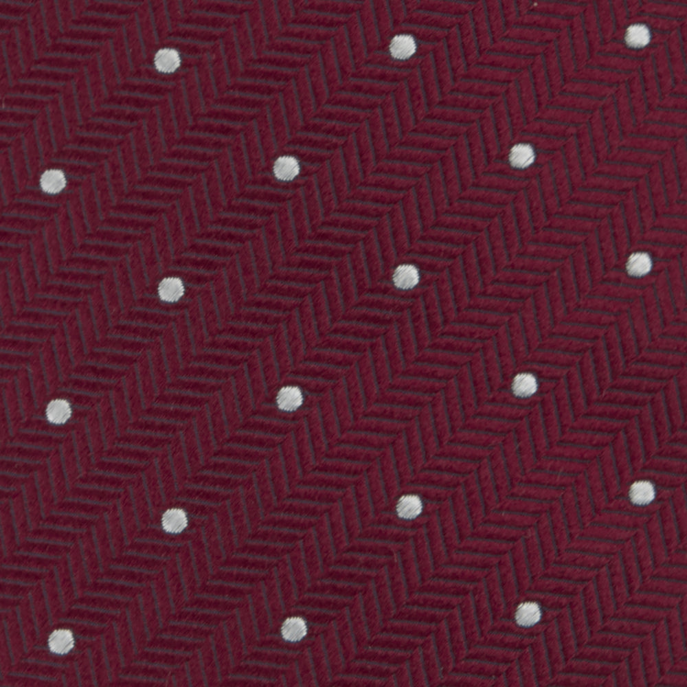 The Turnbull & Asser Burgundy and White Small Spot Herringbone Silk Tie, crafted from fine English silk, is shown rolled up on a plain white background.