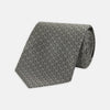 View 1 of product The Turnbull & Asser Grey Floral Spot Silk Tie, shown rolled up on a white background, features a classic black and white spot pattern.