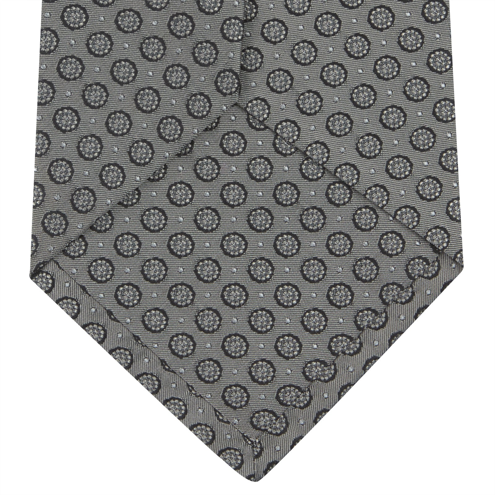 View 4 of product The Turnbull & Asser Grey Floral Spot Silk Tie, shown rolled up on a white background, features a classic black and white spot pattern.