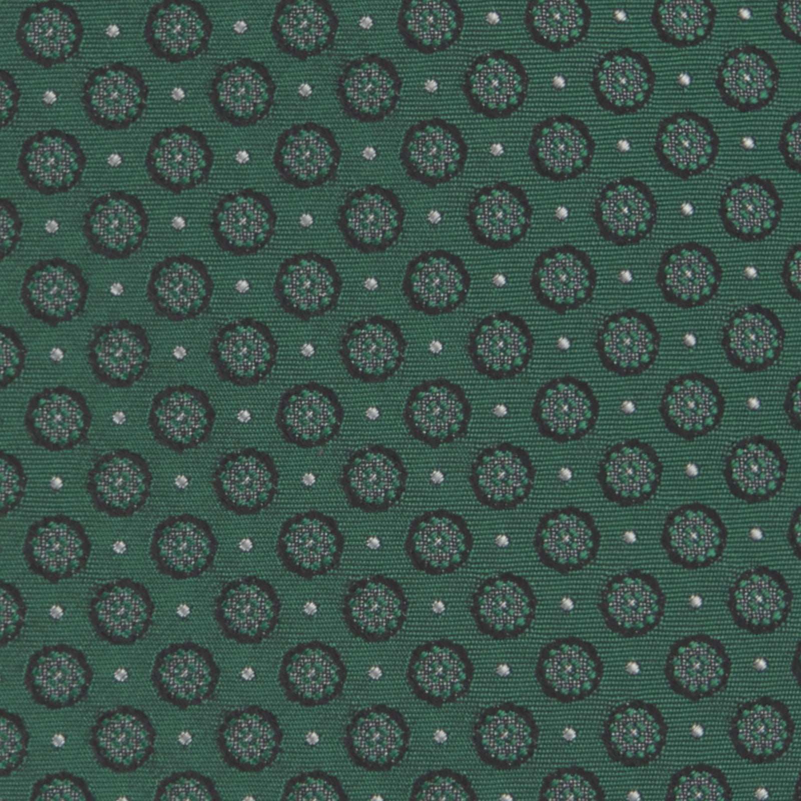 View 3 of product The Turnbull & Asser Green Floral Spot Silk Tie features small, light-colored circular dots on a classic green silk background—ideal for dressing up your favorite office shirt. Displayed rolled on a plain white backdrop.