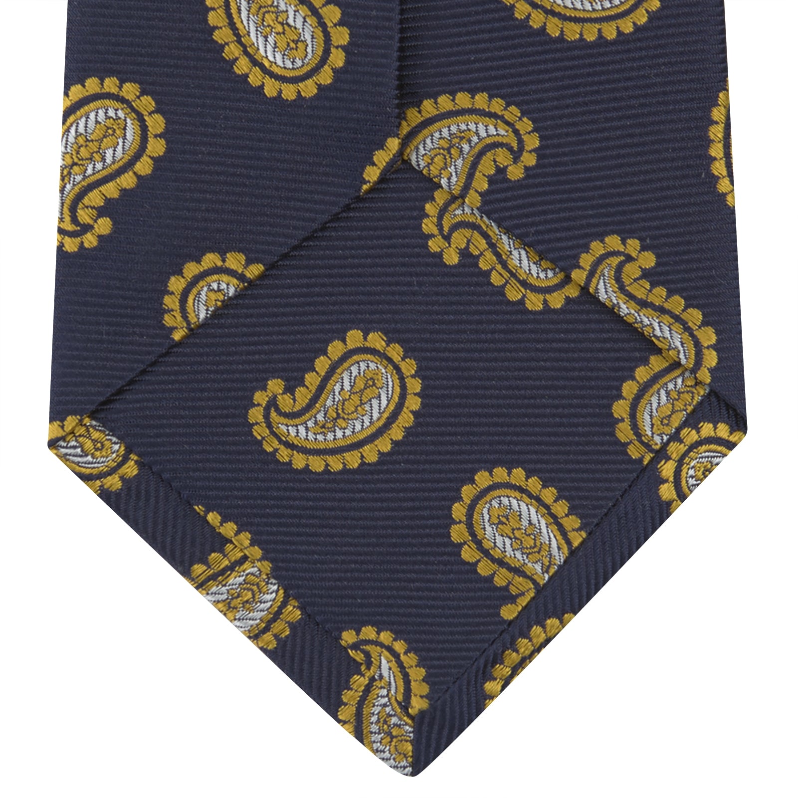 View 4 of product The Turnbull & Asser Navy and Gold Floating Paisley Silk Tie features a repeating yellow and white paisley pattern, shown rolled with the pointed end facing forward against a white background.