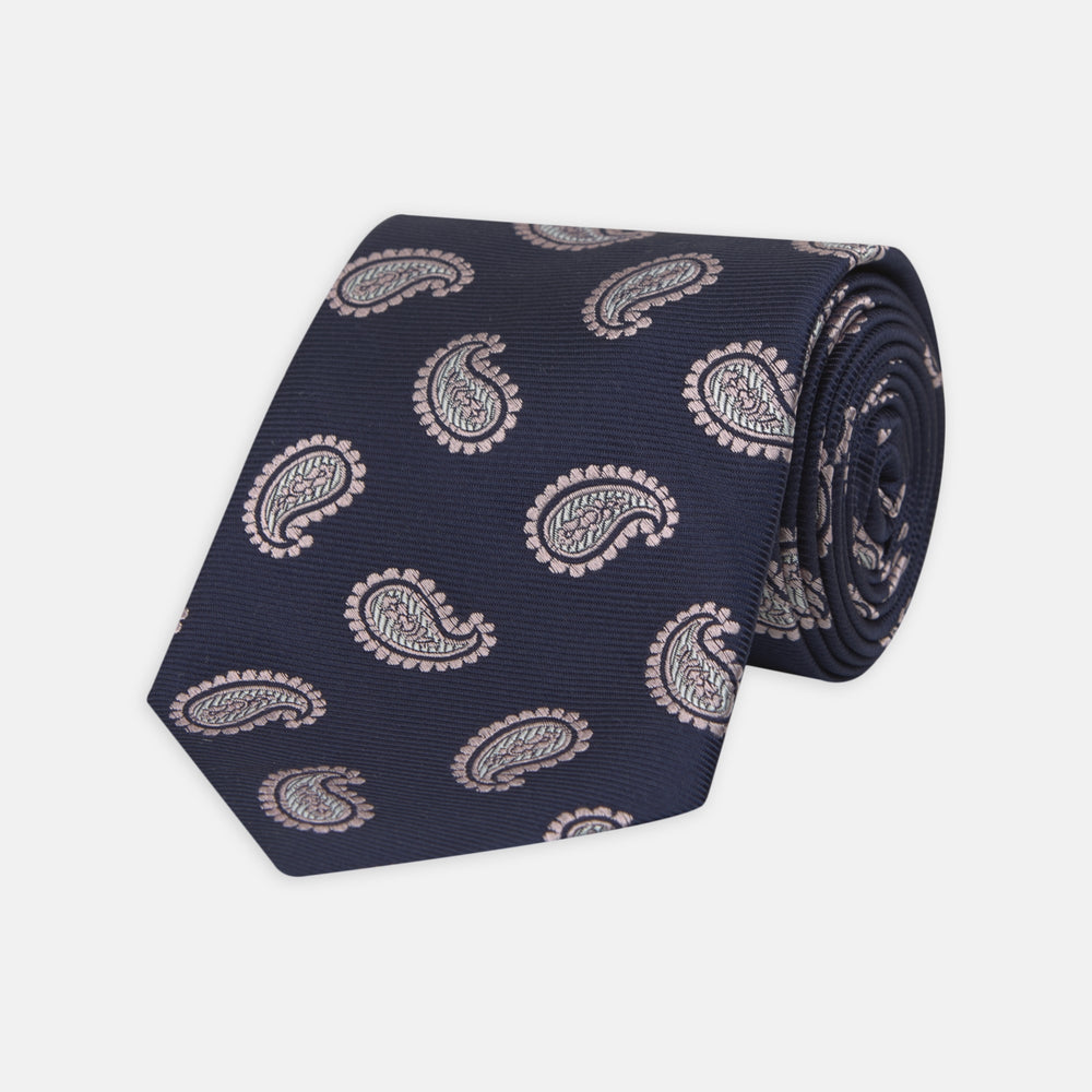 The Turnbull & Asser Navy and Light Pink Floating Paisley Silk Tie features a classic pink and white paisley pattern—a timeless accessory to enhance any wardrobe.