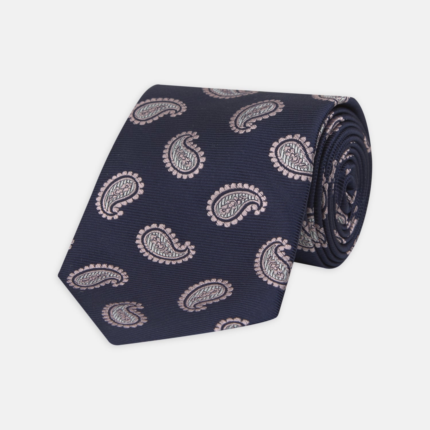 View 1 of product The Turnbull & Asser Navy and Light Pink Floating Paisley Silk Tie features a classic pink and white paisley pattern—a timeless accessory to enhance any wardrobe.