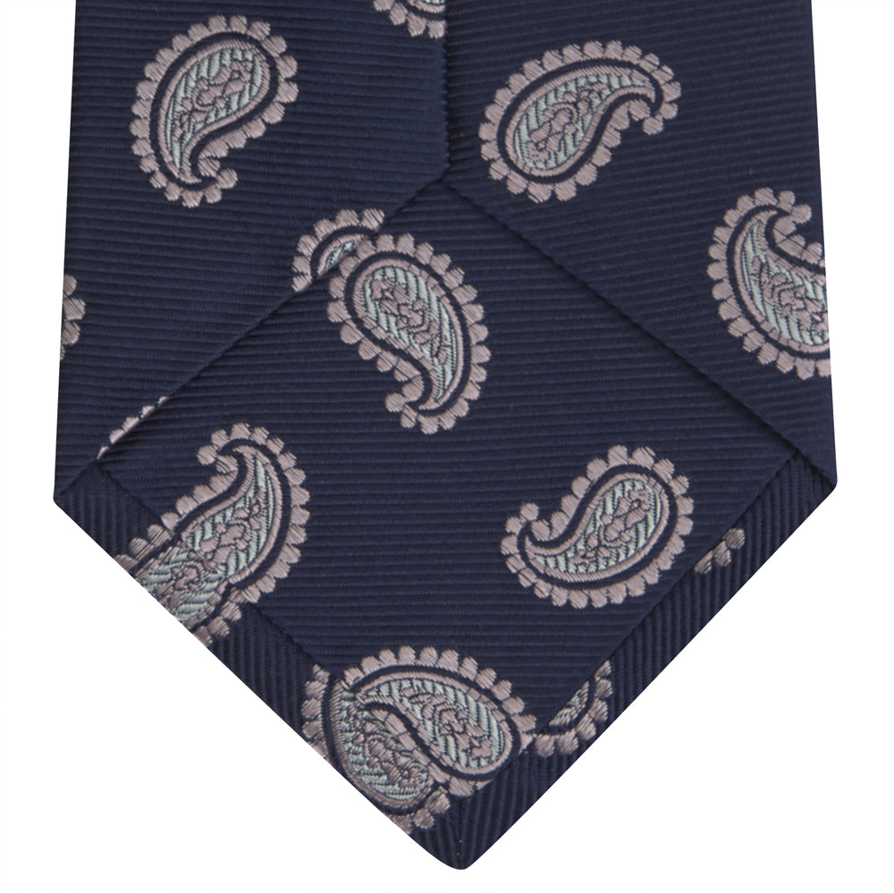 The Turnbull & Asser Navy and Light Pink Floating Paisley Silk Tie features a classic pink and white paisley pattern—a timeless accessory to enhance any wardrobe.