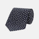 The Turnbull & Asser Navy and White Paint Spot Silk Tie features evenly spaced white spots on classic navy, shown rolled up on a white background—ideal for complementing your favorite office shirt.