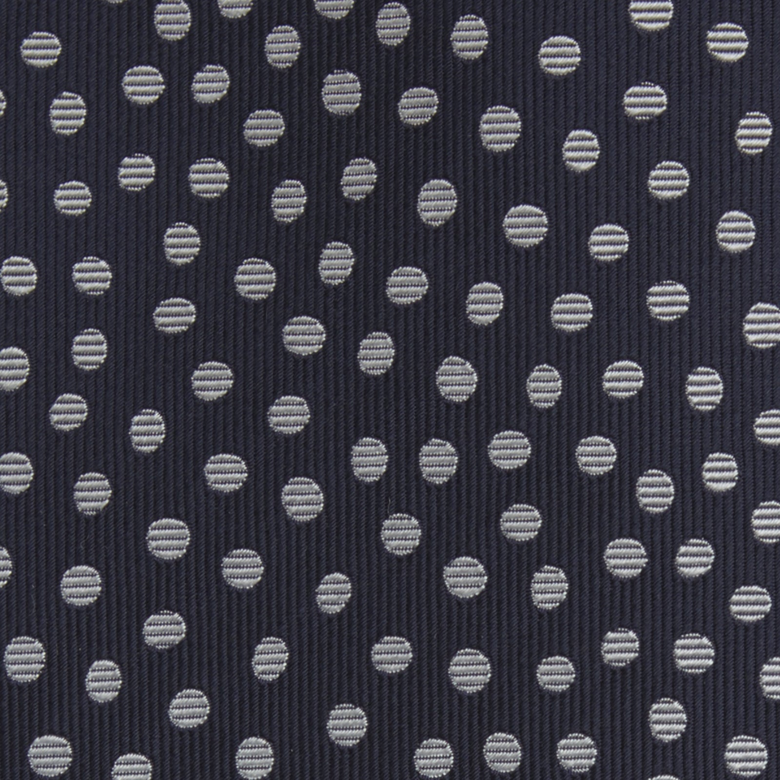 View 3 of product The Turnbull & Asser Navy and White Paint Spot Silk Tie features evenly spaced white spots on classic navy, shown rolled up on a white background—ideal for complementing your favorite office shirt.