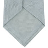 View 4 of product A neatly rolled Turnbull & Asser Light Blue Grenadine Silk Tie, featuring a subtle textured weave, displayed on a white background.