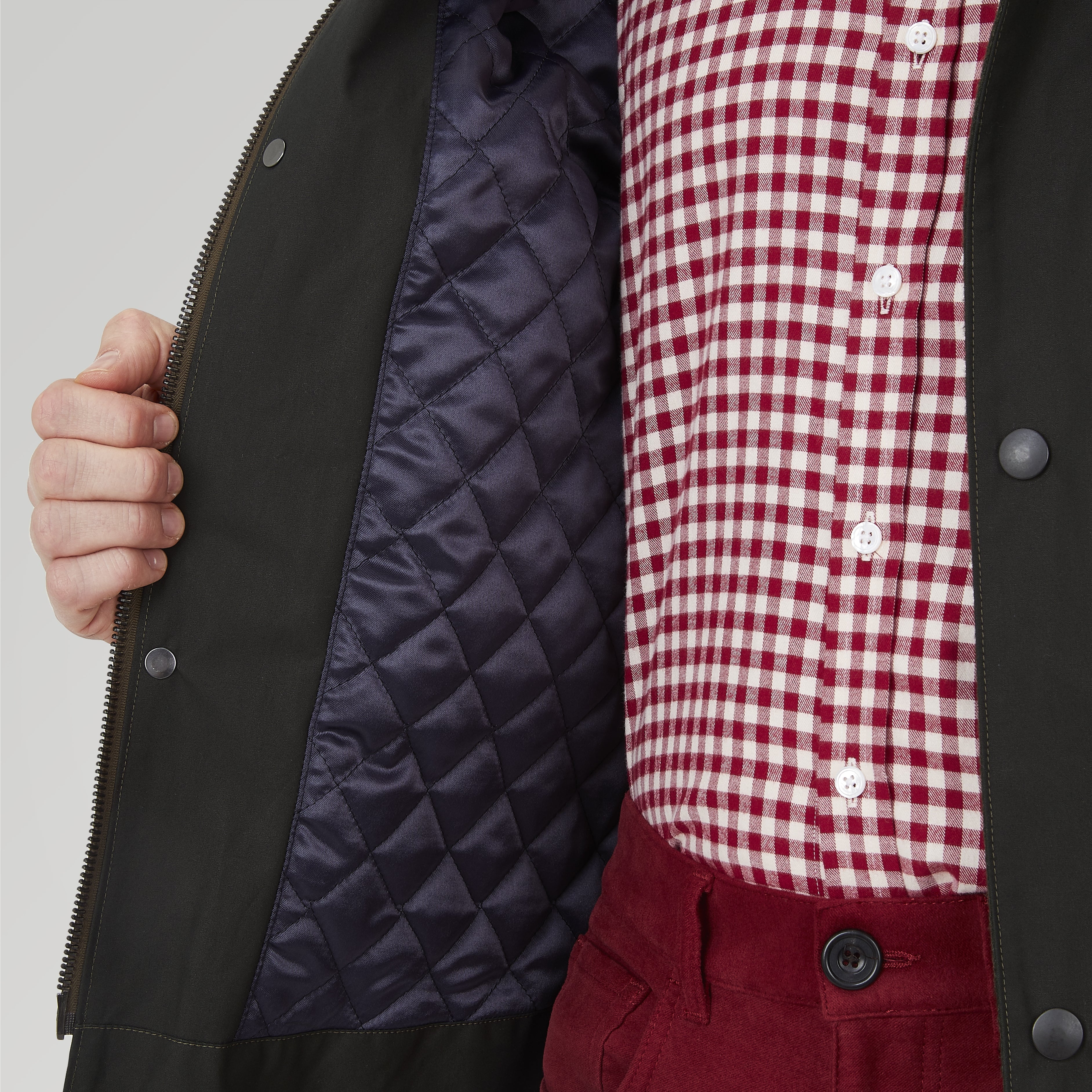 View 4 of product The Turnbull & Asser Dark Green Waxed Cotton Field Coat features a straight fit, button-up front, two large bottom flap pockets, slanted chest pockets, and a contrasting collar. Shown against a plain white background.