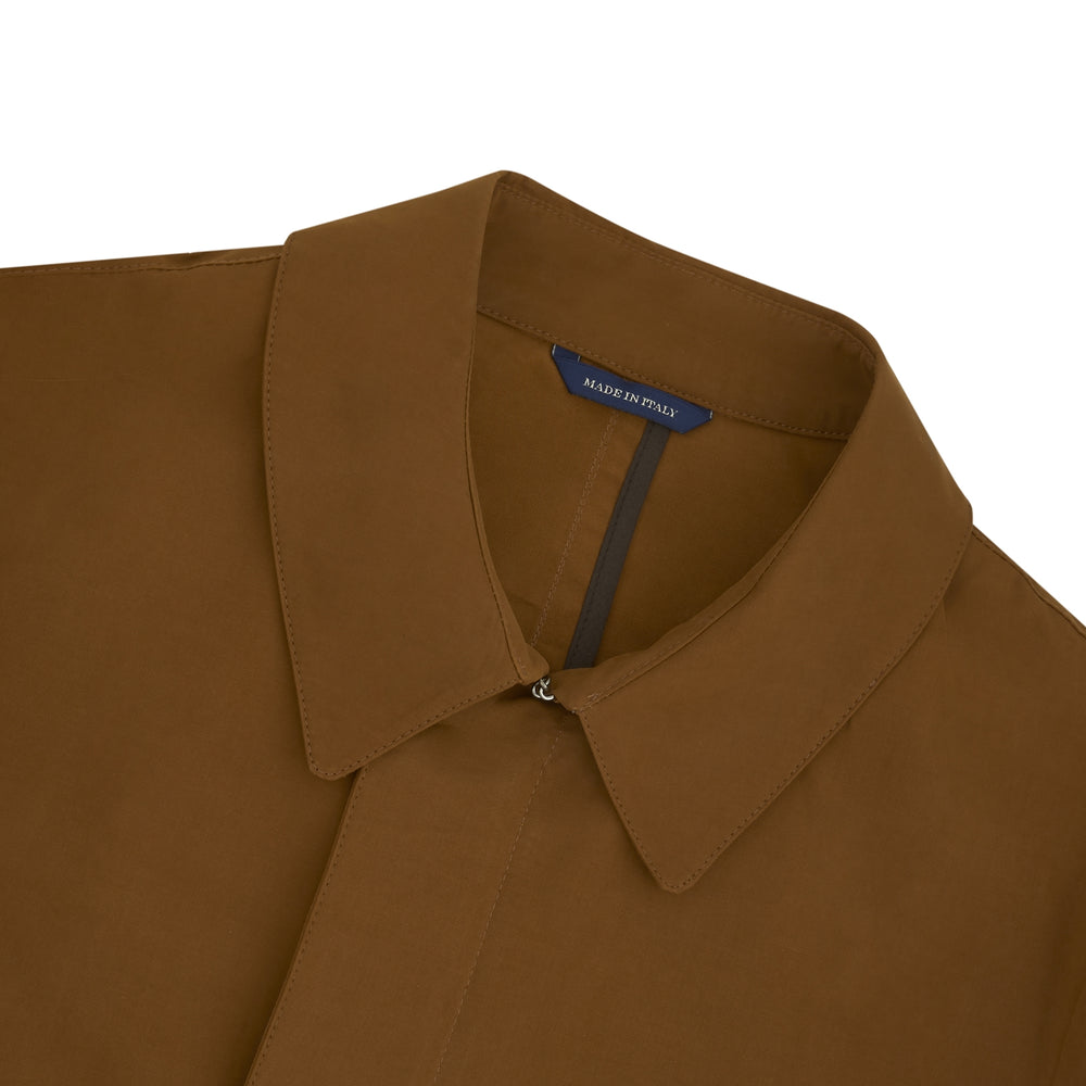 The Turnbull & Asser Dark Khaki Cotton Car Coat features a classic collar, long sleeves, front welt pockets, tailored fit, and concealed button closure in a knee-length modern design, shown against a plain white background.