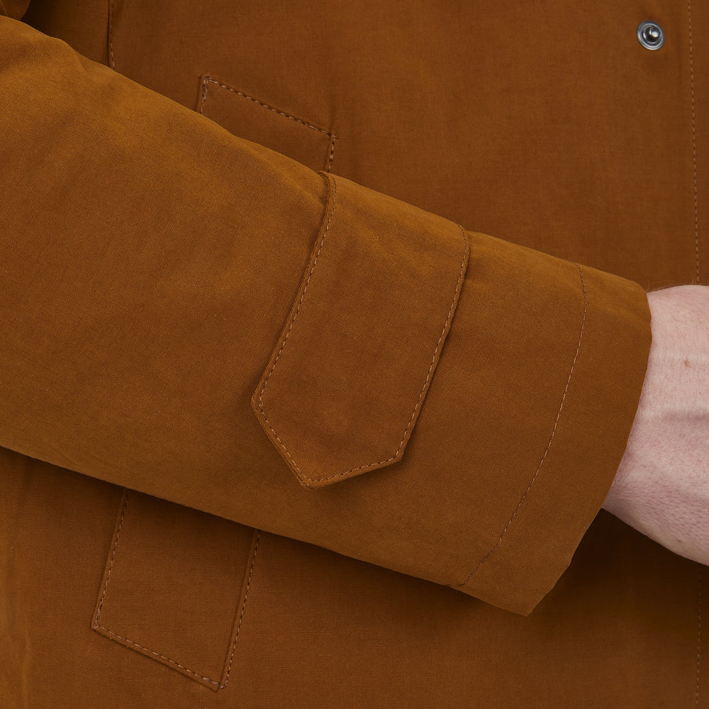 The Turnbull & Asser Dark Khaki Cotton Car Coat features a classic collar, long sleeves, front welt pockets, tailored fit, and concealed button closure in a knee-length modern design, shown against a plain white background.