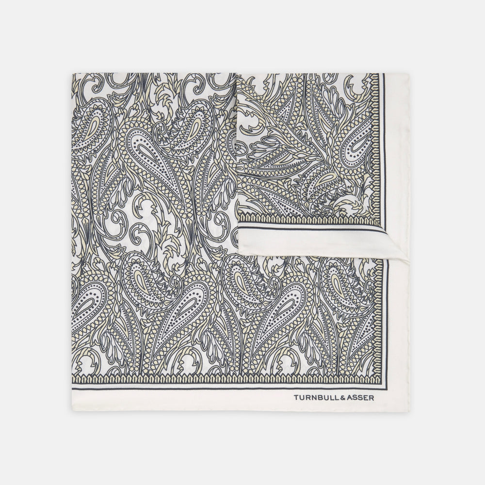 A White and Yellow House Paisley Silk Pocket Square by Turnbull & Asser, featuring an elegant house paisley pattern and the brand name printed in the bottom right corner.