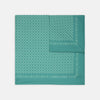 View 1 of product The Kingfisher Green Monocle Silk Pocket Square by Turnbull & Asser features an elegant geometric pattern and border, with the Turnbull & Asser name displayed in white on the lower right corner.