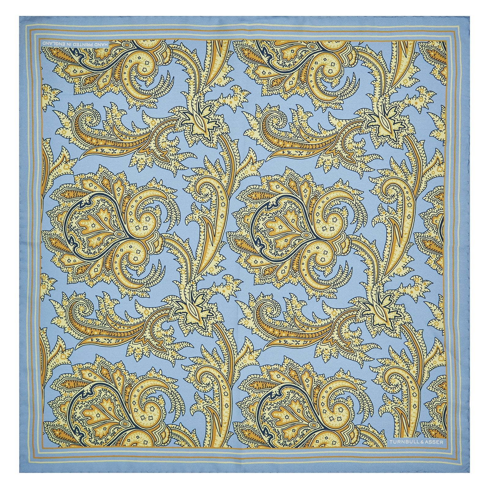 View 2 of product A folded Light Blue and Yellow Large Paisley Silk Pocket Square by Turnbull & Asser features an intricate paisley design. The brand name appears in white on the bottom right corner.