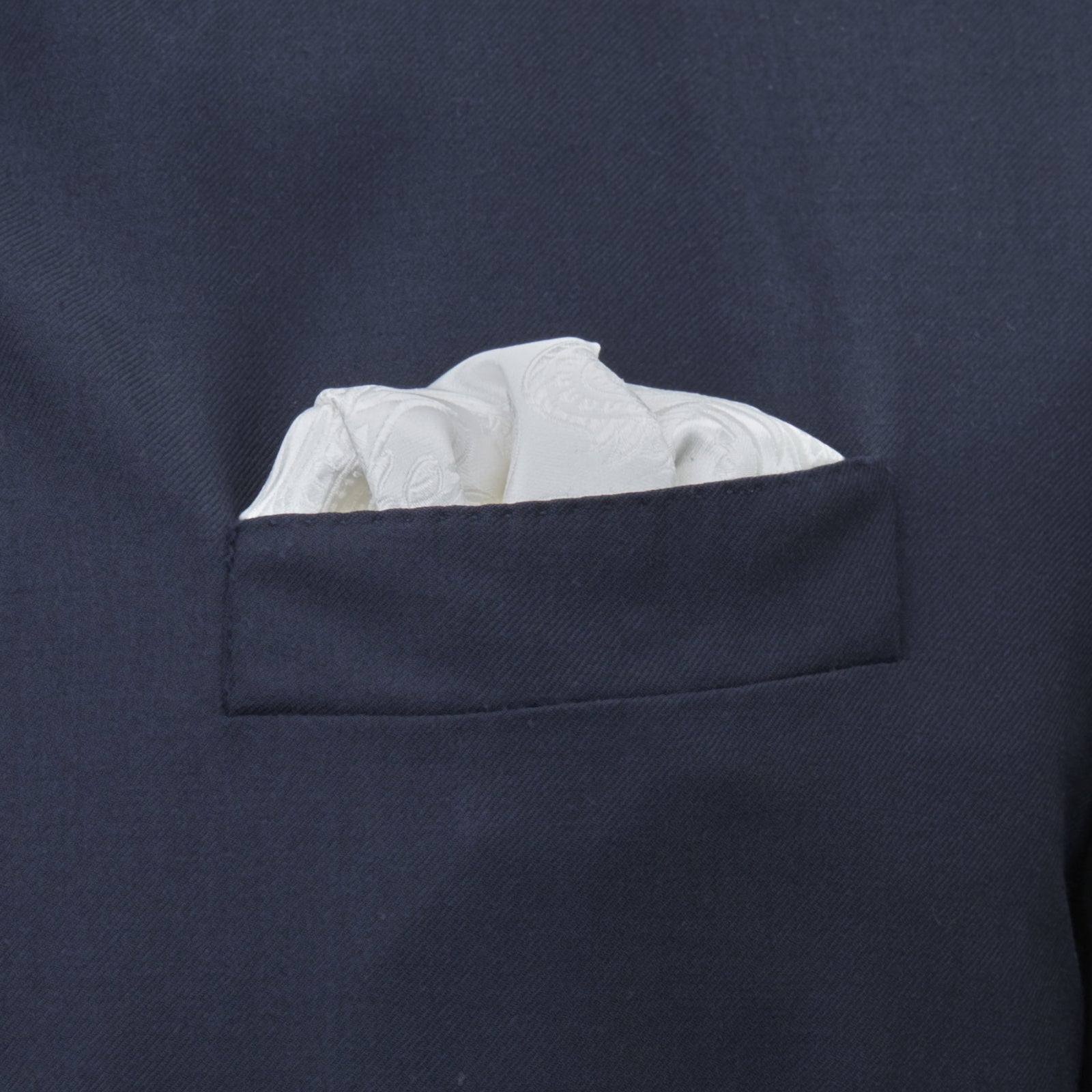 View 4 of product The Turnbull & Asser White House Paisley Hand-Rolled Silk Pocket Square is shown neatly folded to reveal both sides of its white woven fabric, ideal for black tie, set against a light gray background.