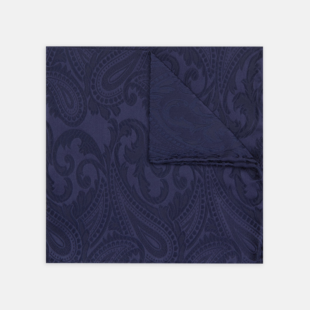 The Navy House Paisley Hand-Rolled Silk Pocket Square by Turnbull & Asser, shown folded to display its pattern against a white background, adds an elegant touch to black tie attire.