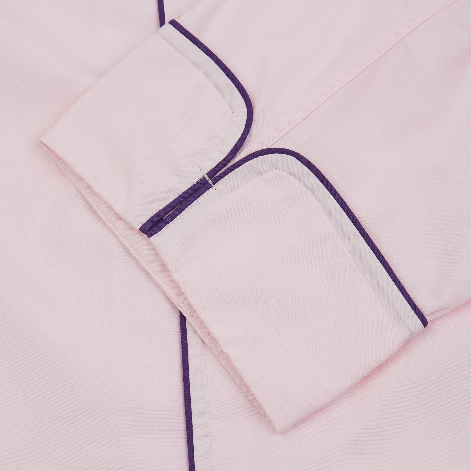 View 4 of product The Turnbull & Asser Pink Piped Cotton Pyjama Set, featuring dark piping on the collar and front with matching pants, is elegantly displayed on a white background—a luxurious sleepwear choice.