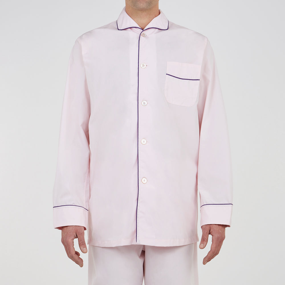 The Turnbull & Asser Pink Piped Cotton Pyjama Set, featuring dark piping on the collar and front with matching pants, is elegantly displayed on a white background—a luxurious sleepwear choice.