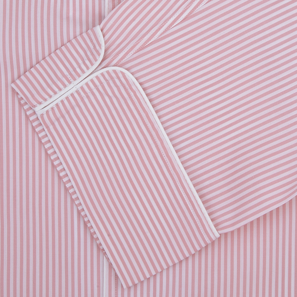 The Turnbull & Asser Pink Bengal Stripe Piped Cotton Pyjama Set features a folded pink and white striped top with white buttons and a matching fabric belt, both displayed flat on a light background.