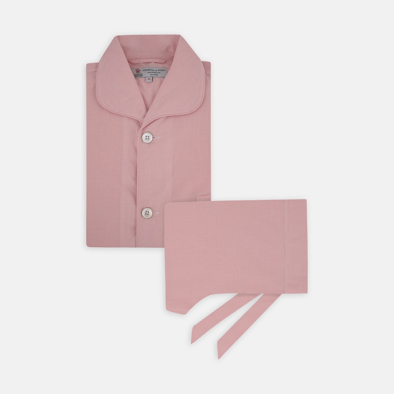 View 1 of product The Turnbull & Asser Pink Micro-Check Piped Cotton Pyjama Set, featuring a pink button-up top with white buttons and a matching headscarf, is displayed on a white background.