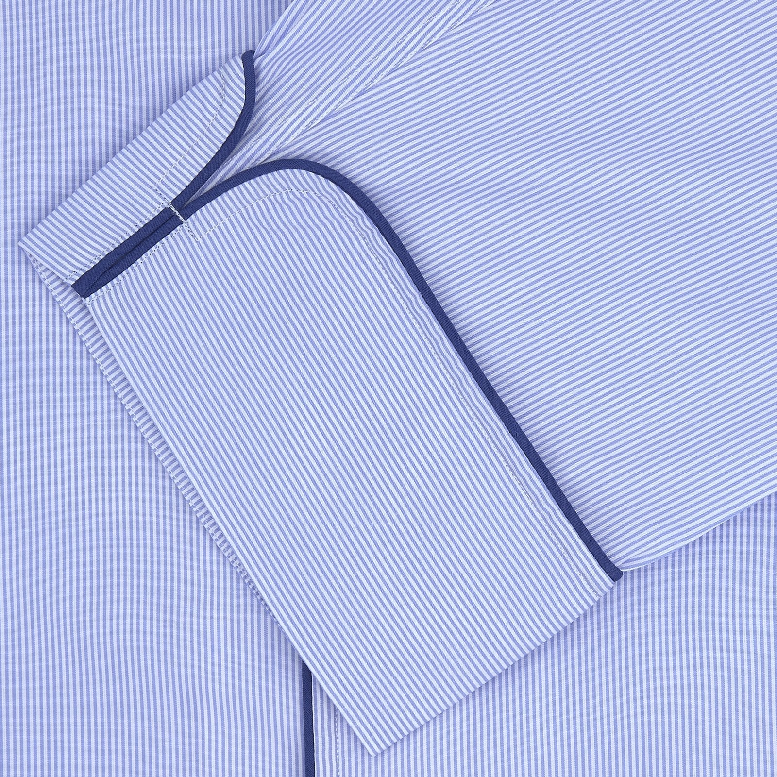 View 2 of product The Turnbull & Asser Blue Fine Stripe Piped Sea Island Quality Cotton Pyjama Set, featuring a button-up shirt and matching nightcap, is neatly folded and displayed on a plain white background.