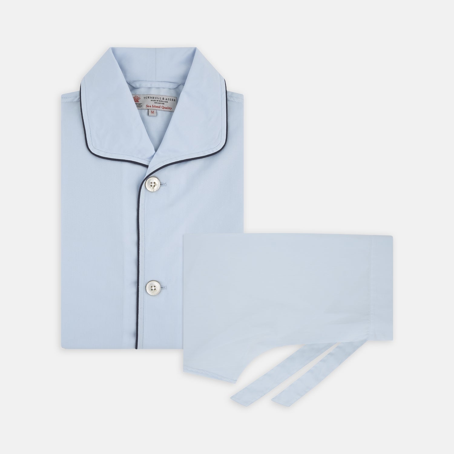 View 1 of product The Light Blue Piped Sea Island Quality Cotton Pyjama Set by Turnbull & Asser, shown with a matching face mask, features dark piping and is crafted from premium cotton, all displayed on a plain white background for a luxurious look.