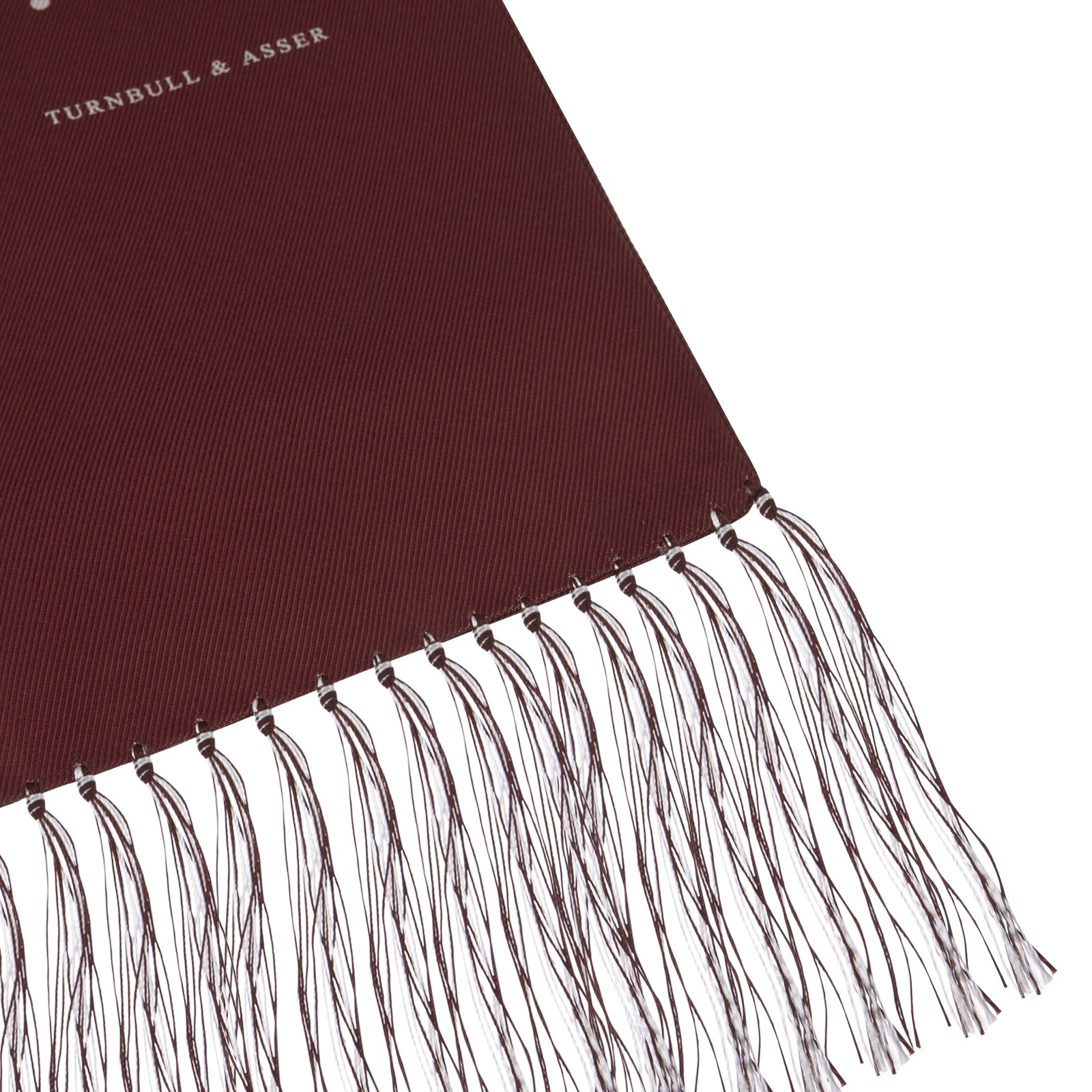 View 2 of product The Turnbull & Asser Wine Spotted Silk Scarf features white polka dots and white fringed ends, elegantly tasseled and neatly folded against a plain white background.