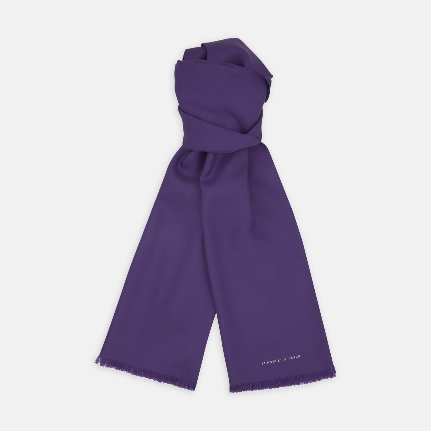 View 1 of product A long, elegant Plain Purple Silk Scarf by Turnbull & Asser, crafted from silk with fringed ends and neatly folded, makes a stylish accessory for any wardrobe.